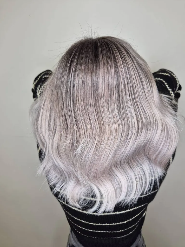 Păr vopsit blond lavandă, cu rădăcină umbrită și bucle largi