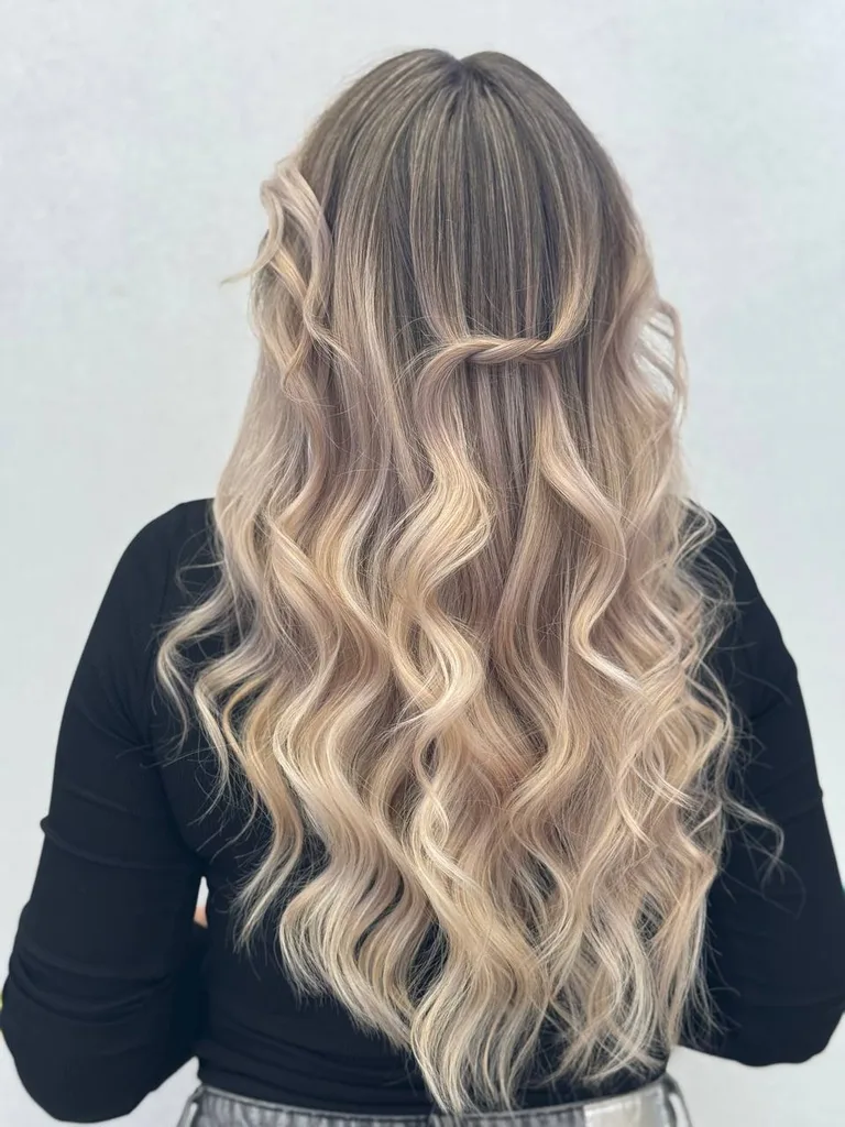 Balayage blond cald pe păr lung cu bucle definite