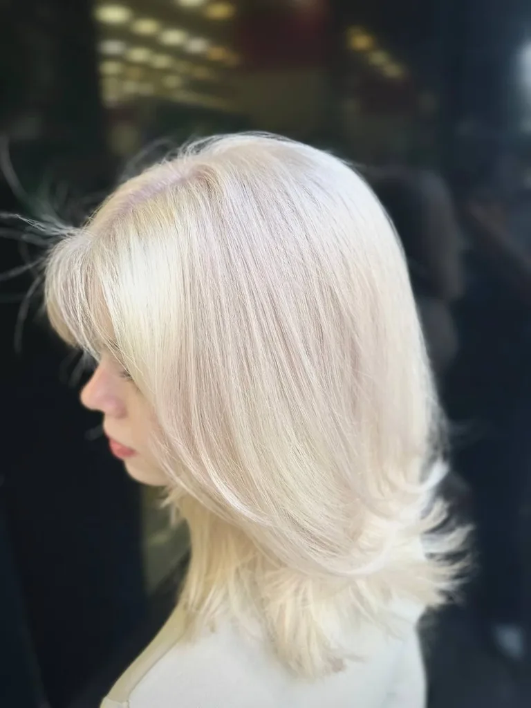 Păr blond platinat cu breton lateral și straturi