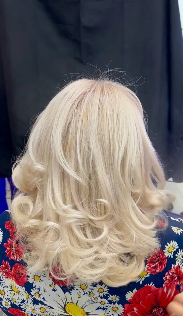 Păr blond deschis, lungime medie, coafat cu volum
