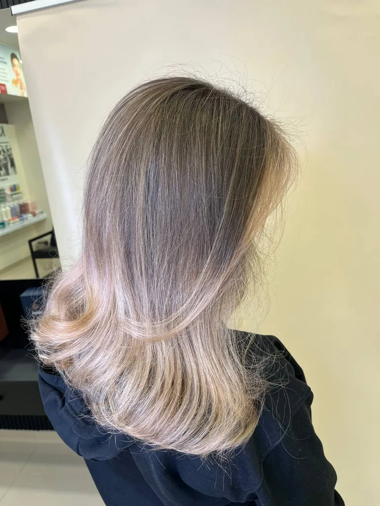 Păr vopsit blond cenușiu, lung, cu vârfuri întoarse, din profil