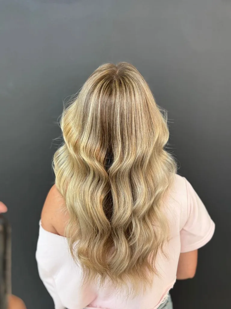 Balayage blond auriu pe bază închisă, păr lung și ondulat